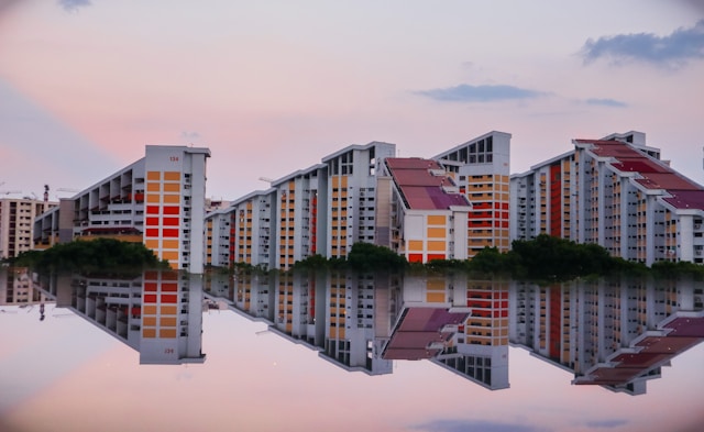 Residential blocks reflected in still water at sunset