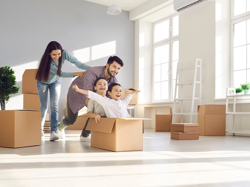 Family unpacking moving boxes in a bright new home
